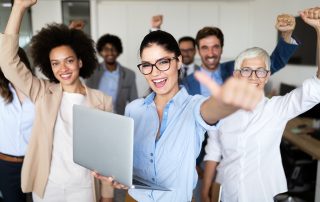 Business team of people posing with thumbs up.